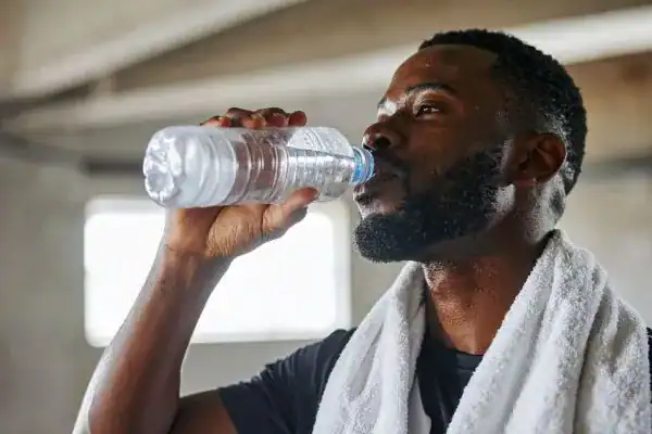 Hydration: The Secret Ingredient for a Toned Stomach and Enhanced Fitness 1 Image of man drinking water to improve hydration Dover after work out.